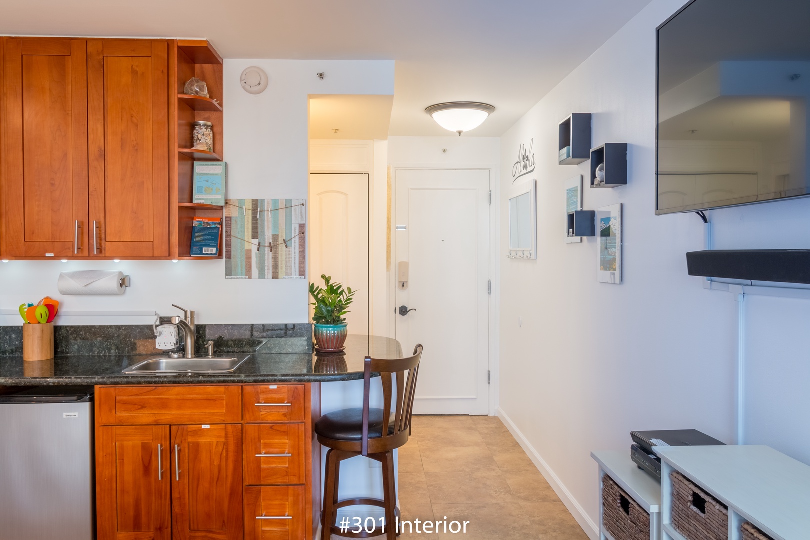Your open-concept space blends warm wood cabinetry with sleek granite counters, creating a cozy spot to prep meals and unwind with your favorite shows after a day of exploring.