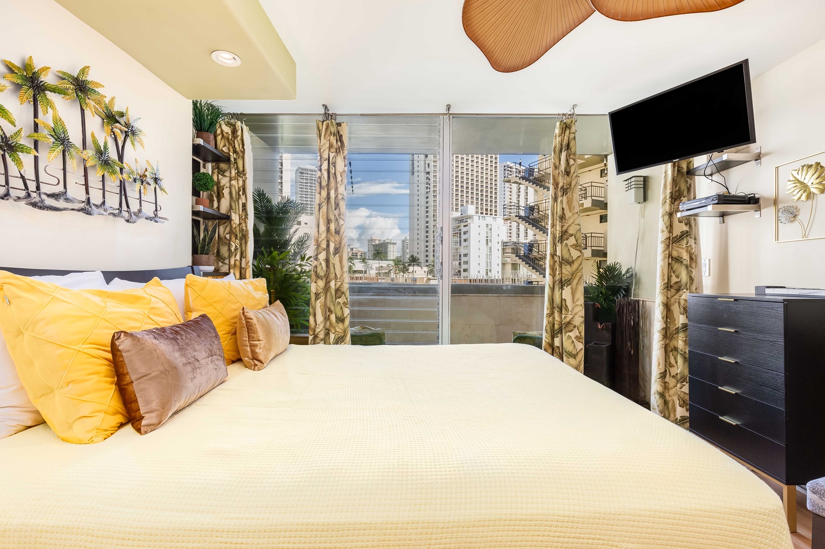 Sink into crisp linens with vibrant pops of yellow and tropical palm artwork welcoming your arrival. Step through sliding glass doors to your private balcony, where urban skyline views await.