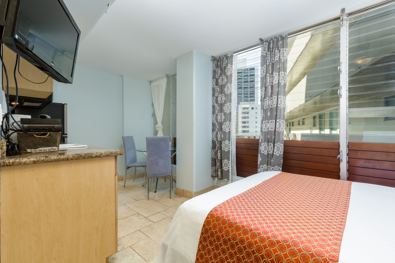 Your cozy studio awaits with a comfy bed, dining nook, and private balcony with city views—perfect for relaxing after exploring the area.