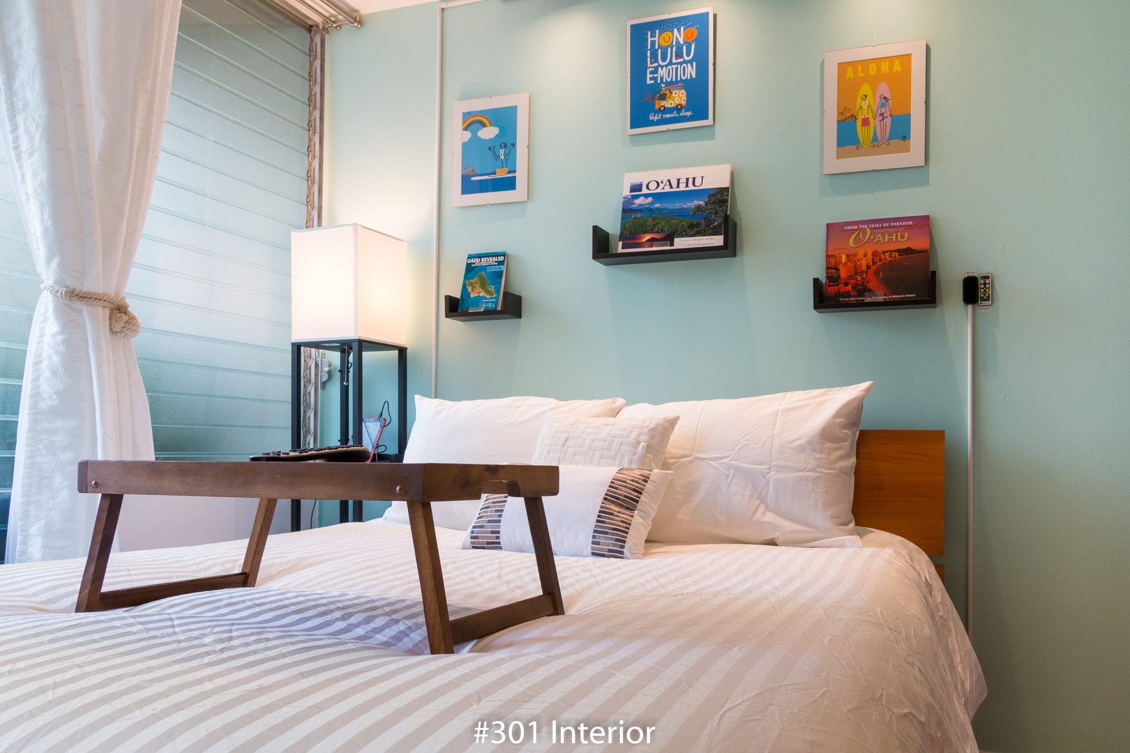 Sink into crisp, white linens and let tropical-themed artwork transport you to island dreams. Your bedside lamp casts a warm glow for late-night reading or peaceful mornings.