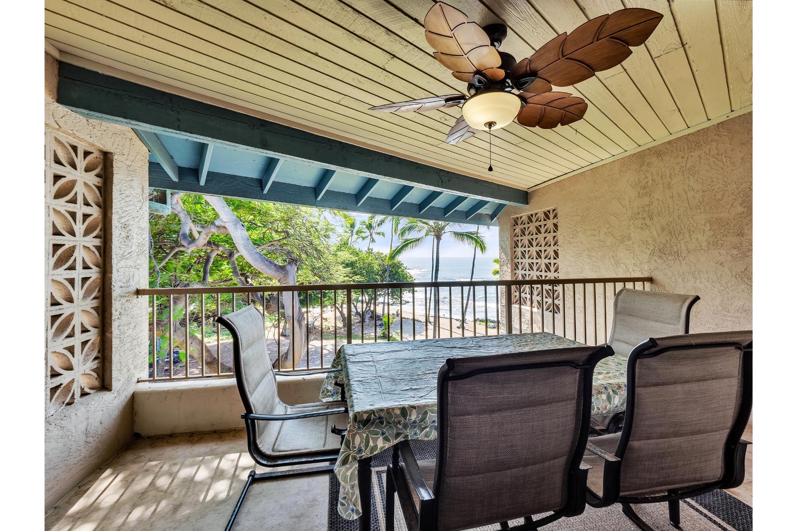 Relax on your private covered lanai with tropical leaf ceiling fan and ocean views through swaying palms.