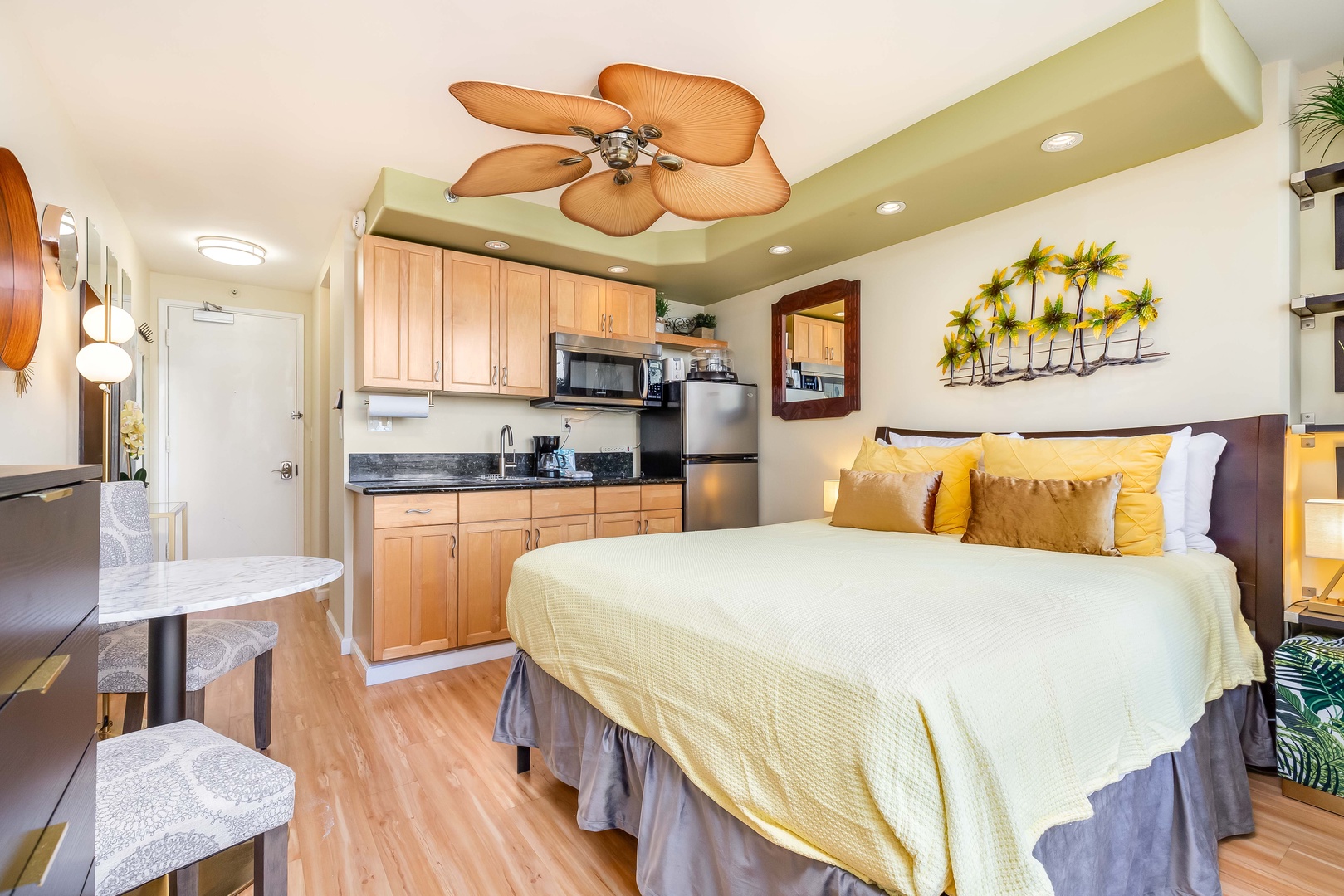 Your bright studio blends tropical charm with modern comfort. Sink into soft bedding under a palm-inspired ceiling fan, with a full kitchenette and dining nook steps away for easy meal prep.