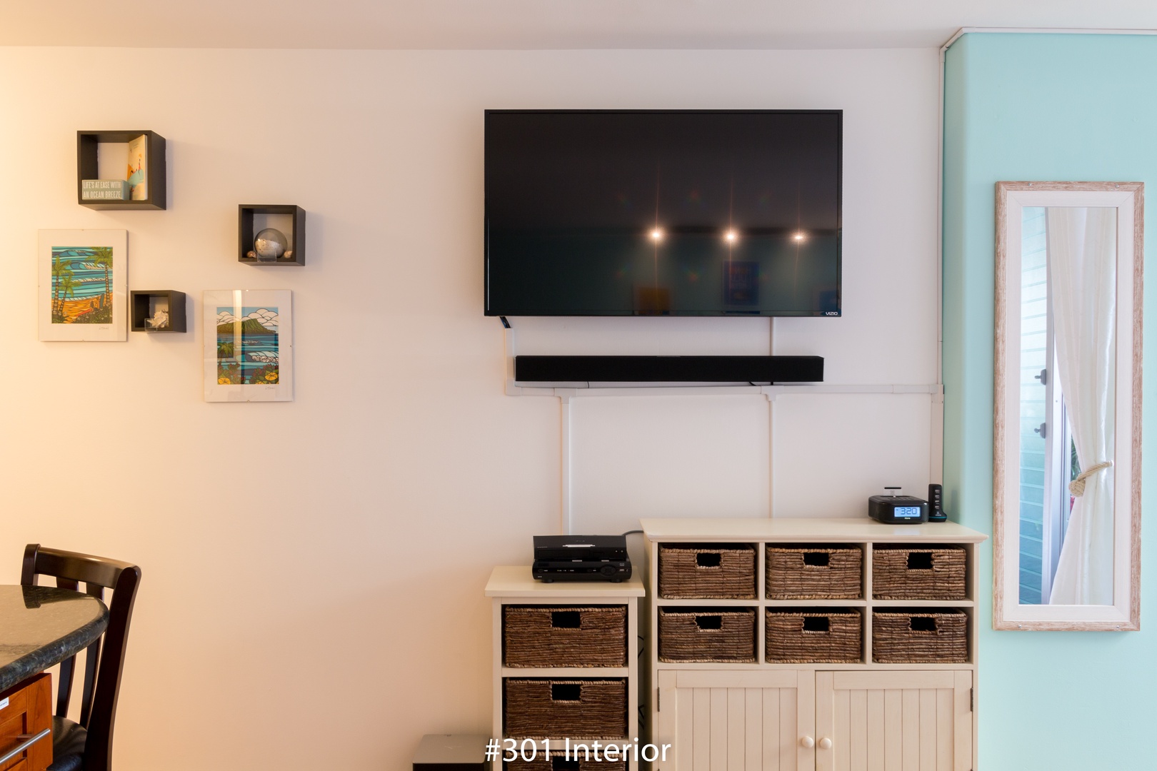 Your entertainment center combines style and function, with a modern flat-screen TV, sound system, and ample storage in charming woven baskets—perfect for cozy movie nights after exploring the area.