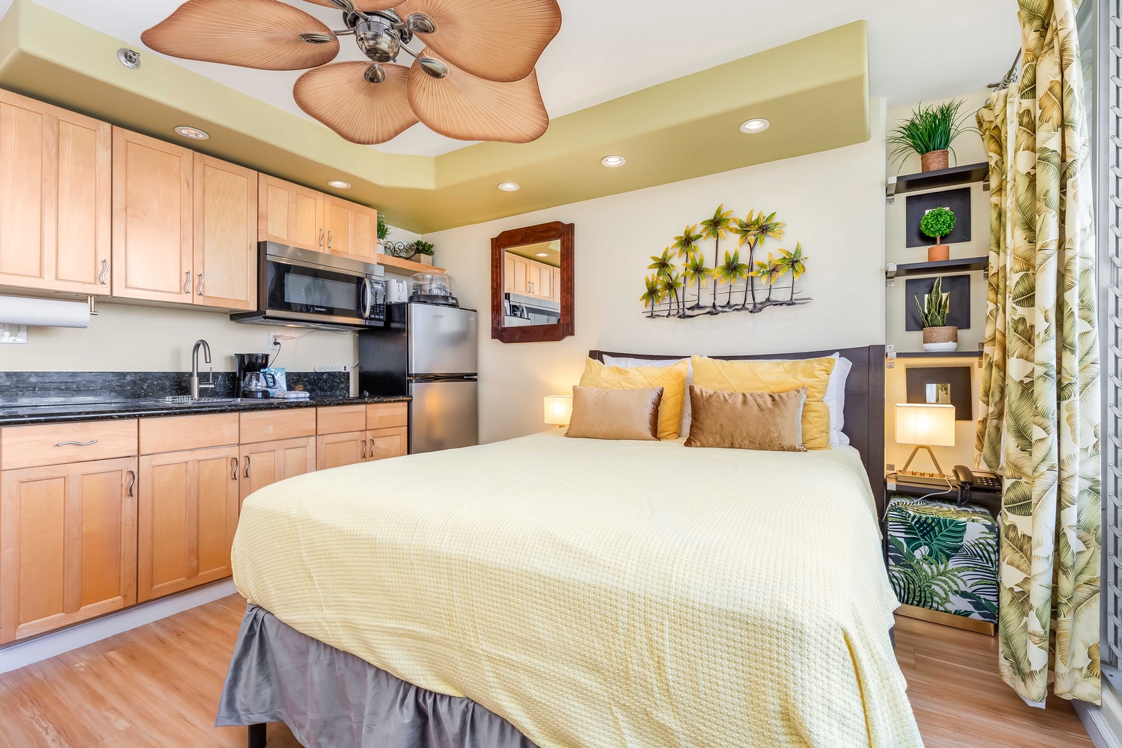 Your tropical-inspired studio pairs comfort and convenience, with a plush bed beneath a palm-leaf ceiling fan and a full kitchenette just steps away—perfect for unwinding after island adventures.