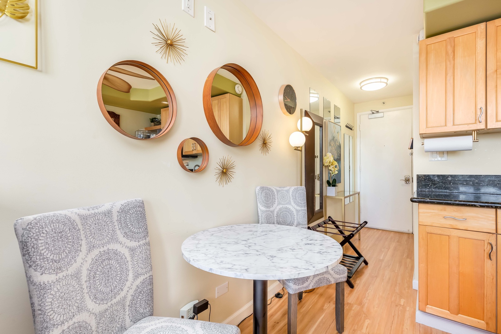 Your cozy dining nook features a marble bistro table framed by stylish round mirrors, creating an inviting spot for morning coffee or intimate meals in your light-filled retreat.
