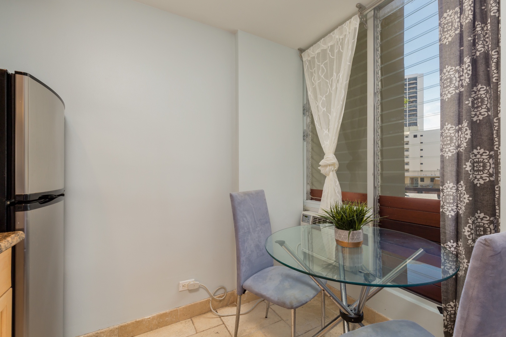 Relax at your private glass table for intimate meals or morning coffee while you take in the urban views through your window. The cozy seating makes it perfect for quiet moments.