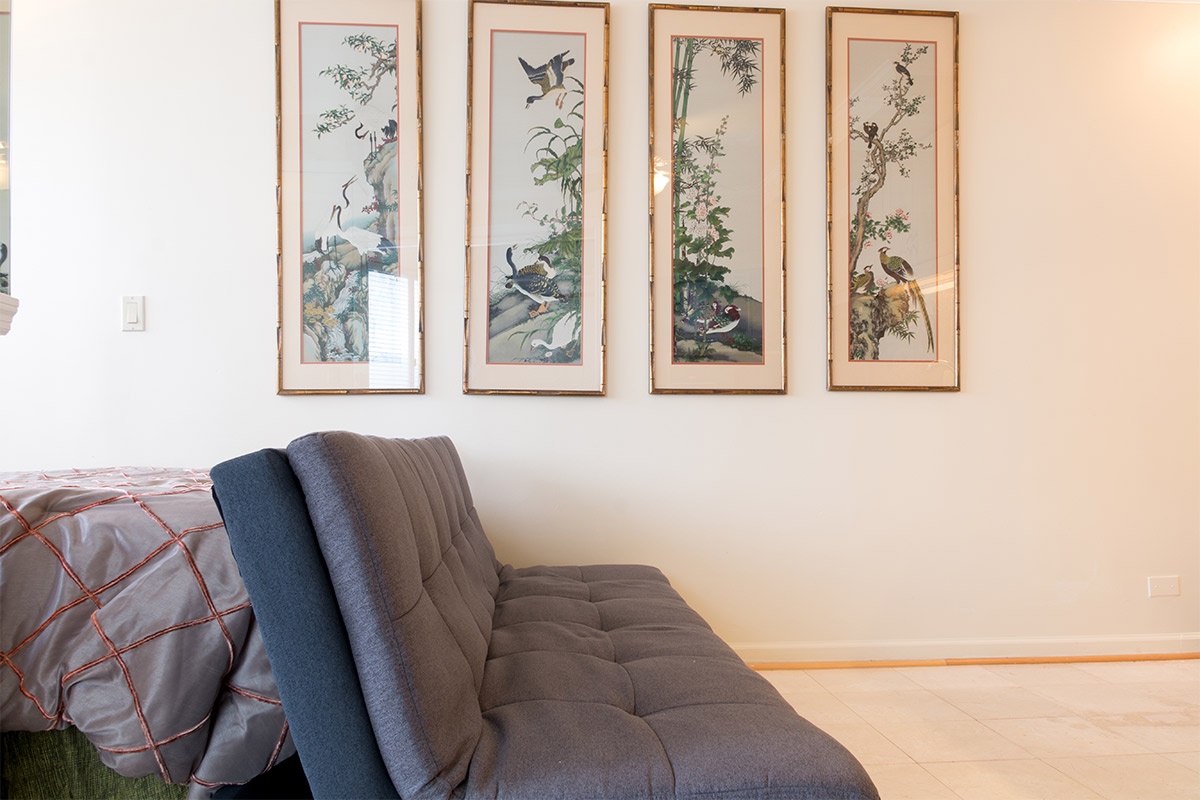 Unwind on the cozy seating area beneath elegant nature-inspired artwork, where your morning coffee or evening read feels peacefully at home.