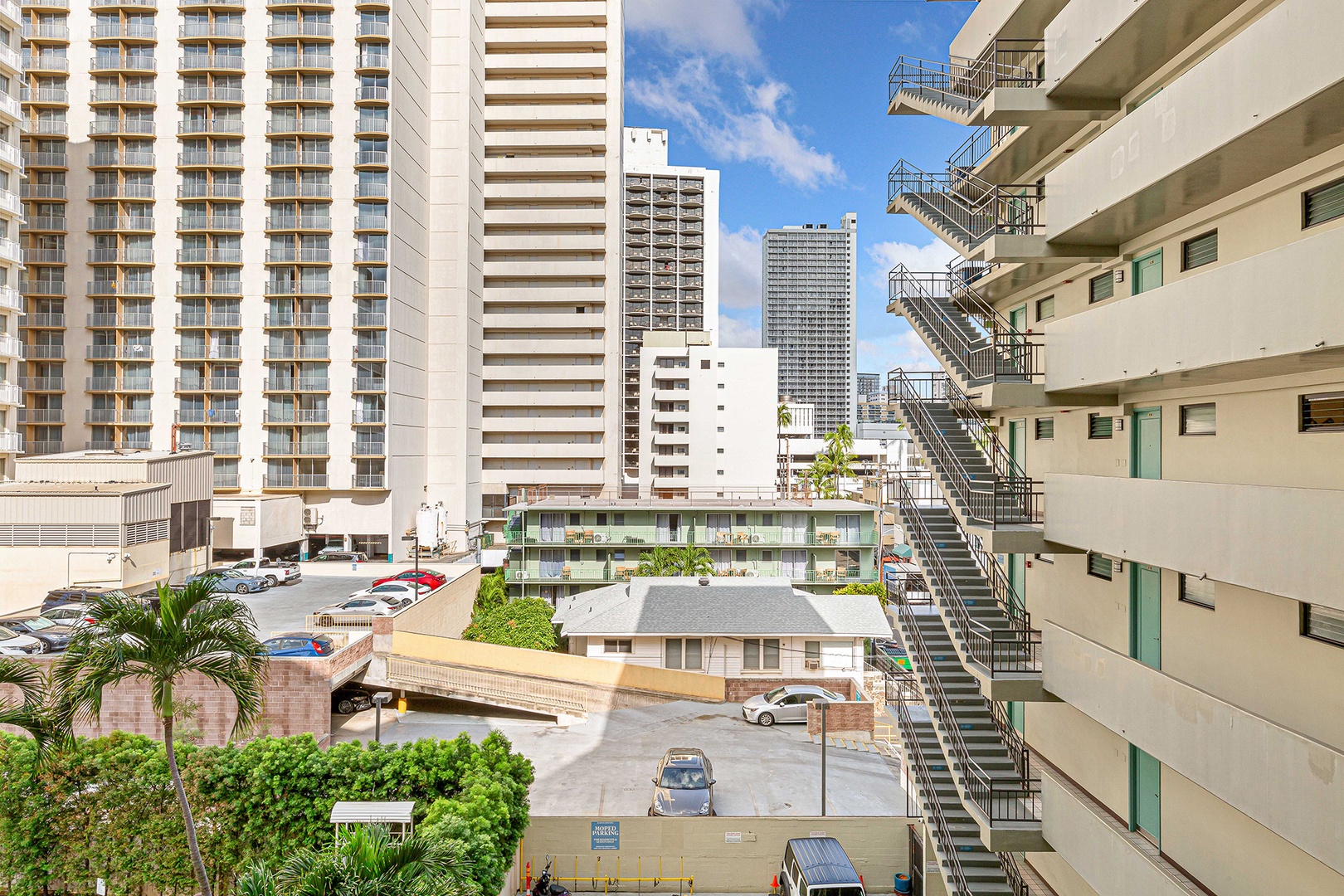 Urban cityscape with high-rise towers, parking area, and nearby buildings characteristic of the surrounding neighborhood.