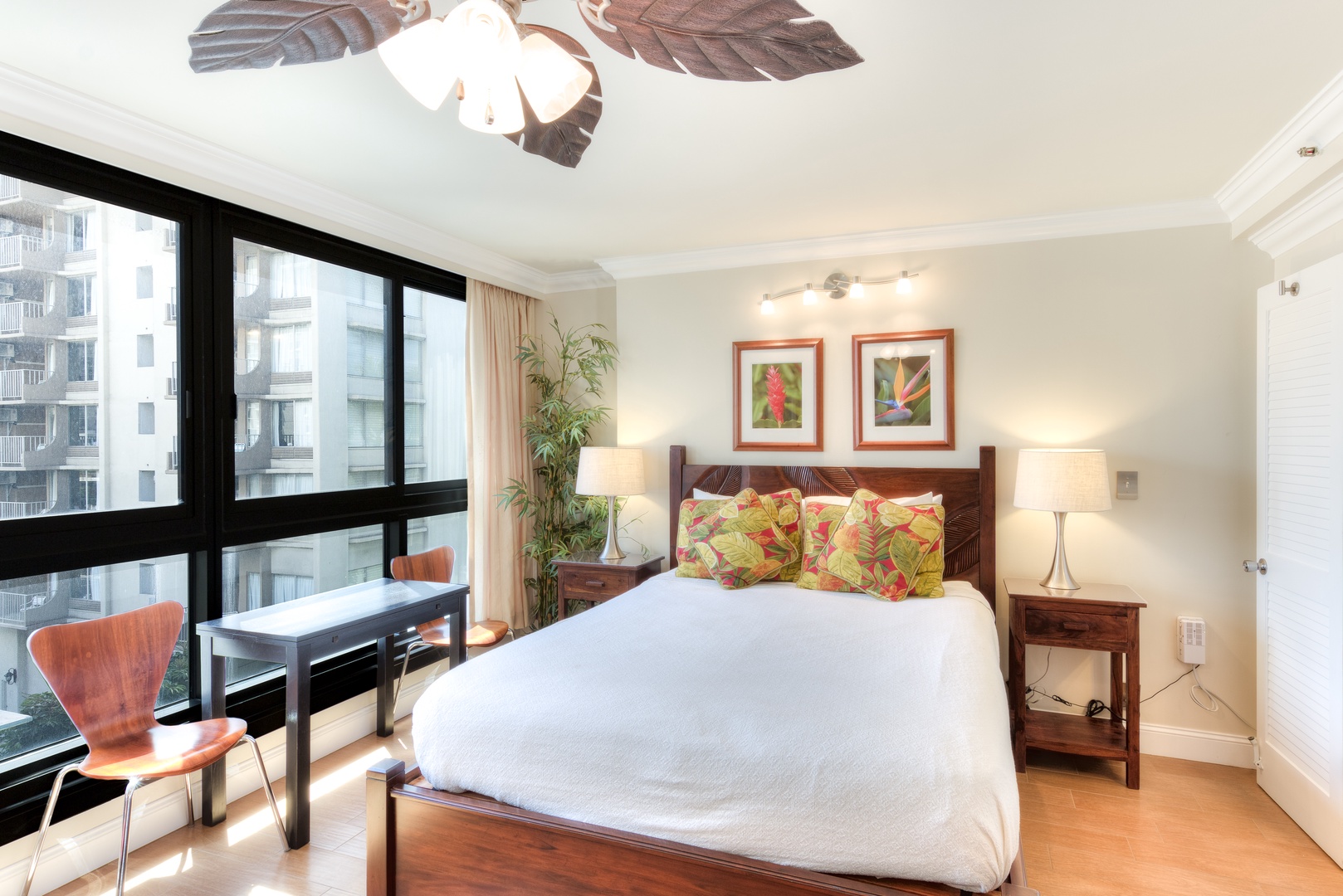 Your bright bedroom features tropical-inspired décor, warm wood furnishings, and floor-to-ceiling windows overlooking the city—perfect for restful mornings and relaxing evenings.