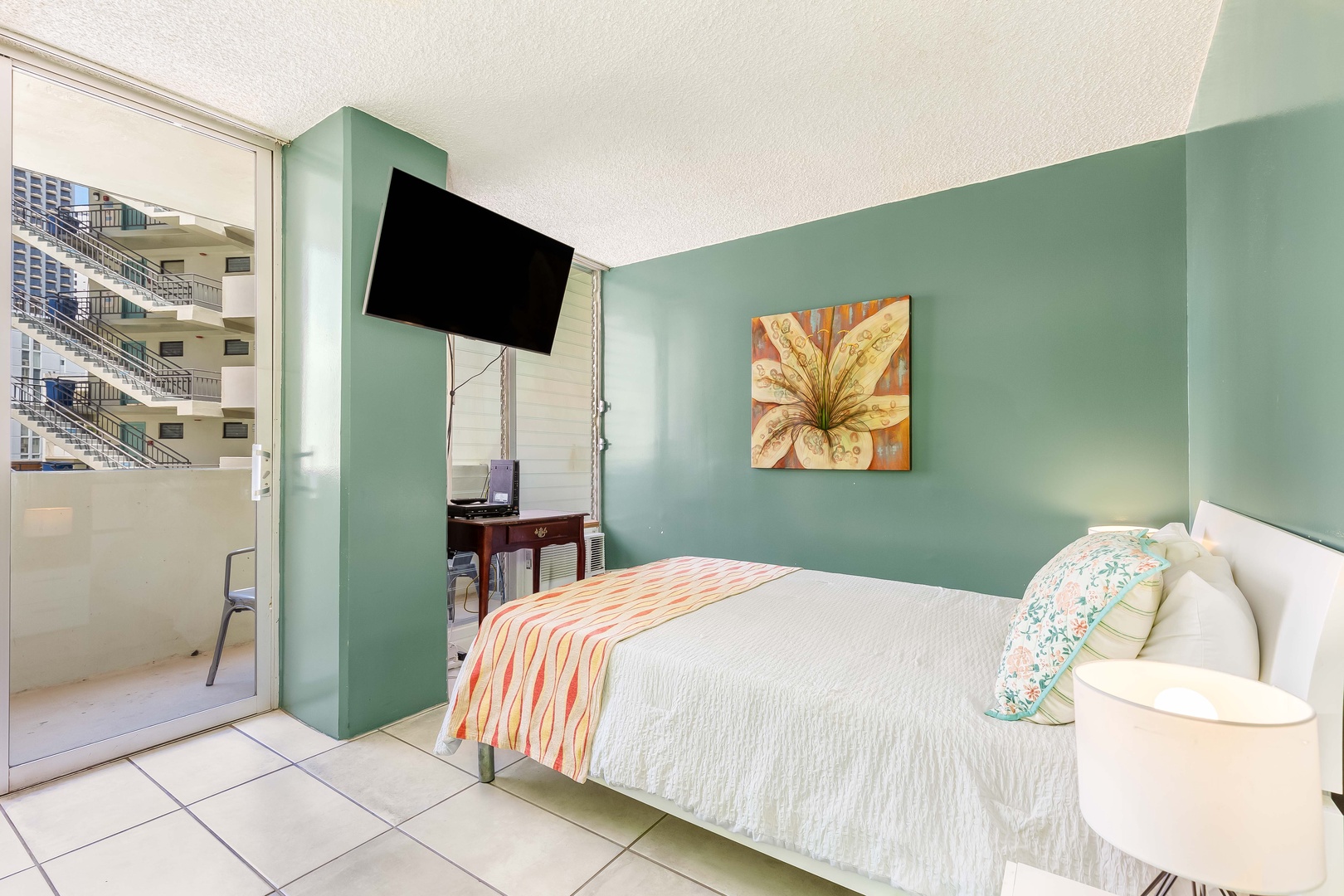 Sink into crisp white linens in your coastal-inspired bedroom with calming sage walls and a flat-screen TV for your relaxation. Step through the glass door to your private balcony with city views.