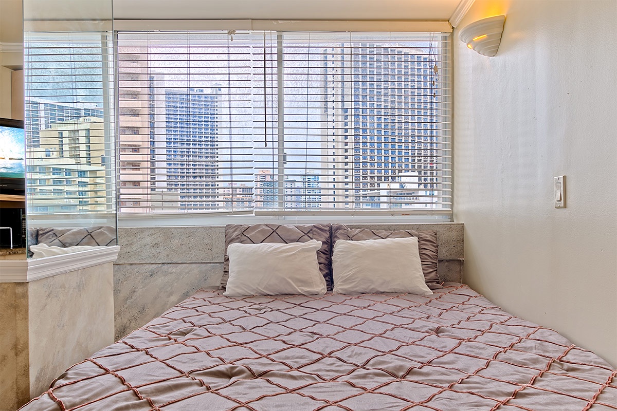 Wake up each morning in this chic bedroom, where large windows frame stunning city views and soft linens invite you to relax.