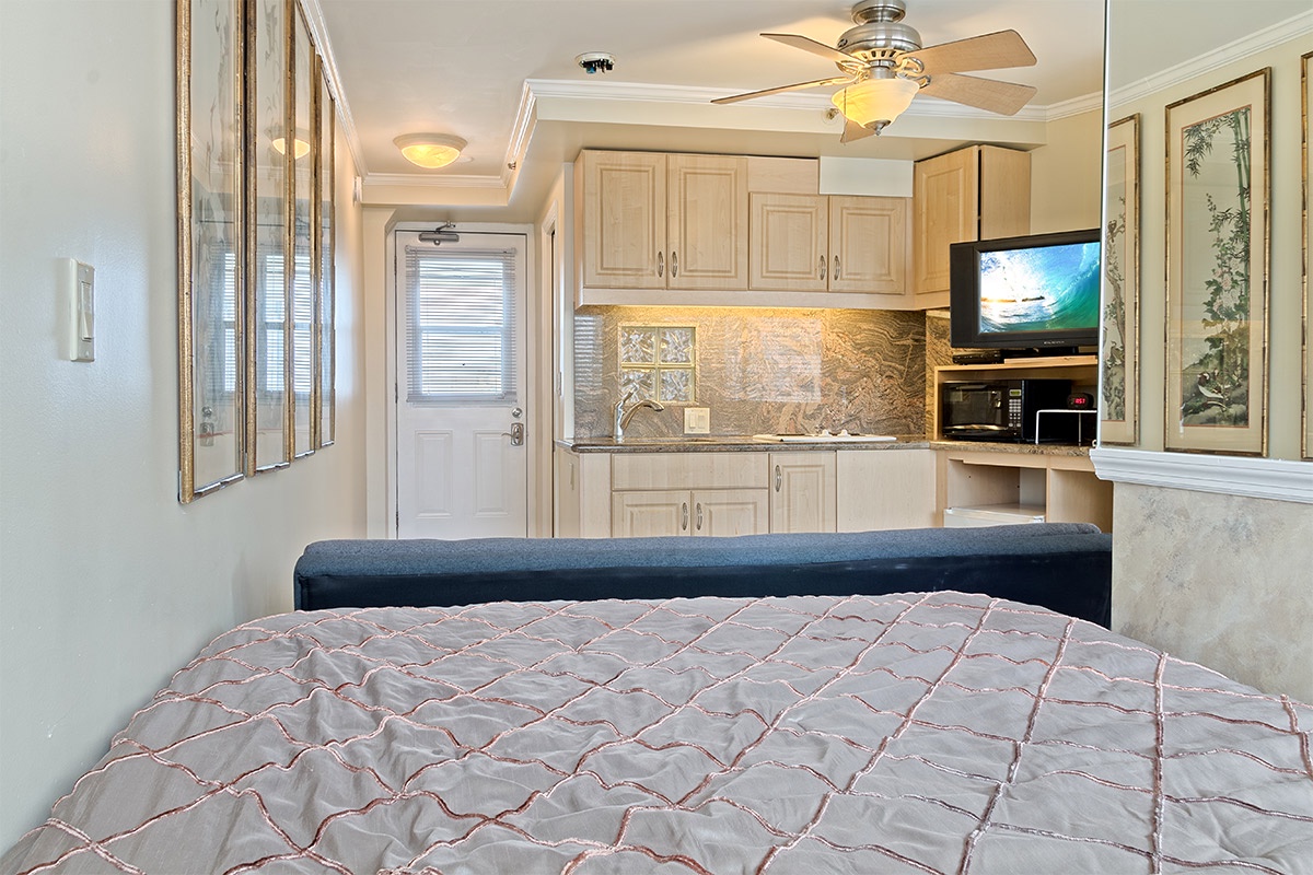 Step into your cozy retreat where soft lighting and a warm color palette invite you to unwind. The kitchenette's gleaming backsplash and modern appliances await your morning coffee ritual.