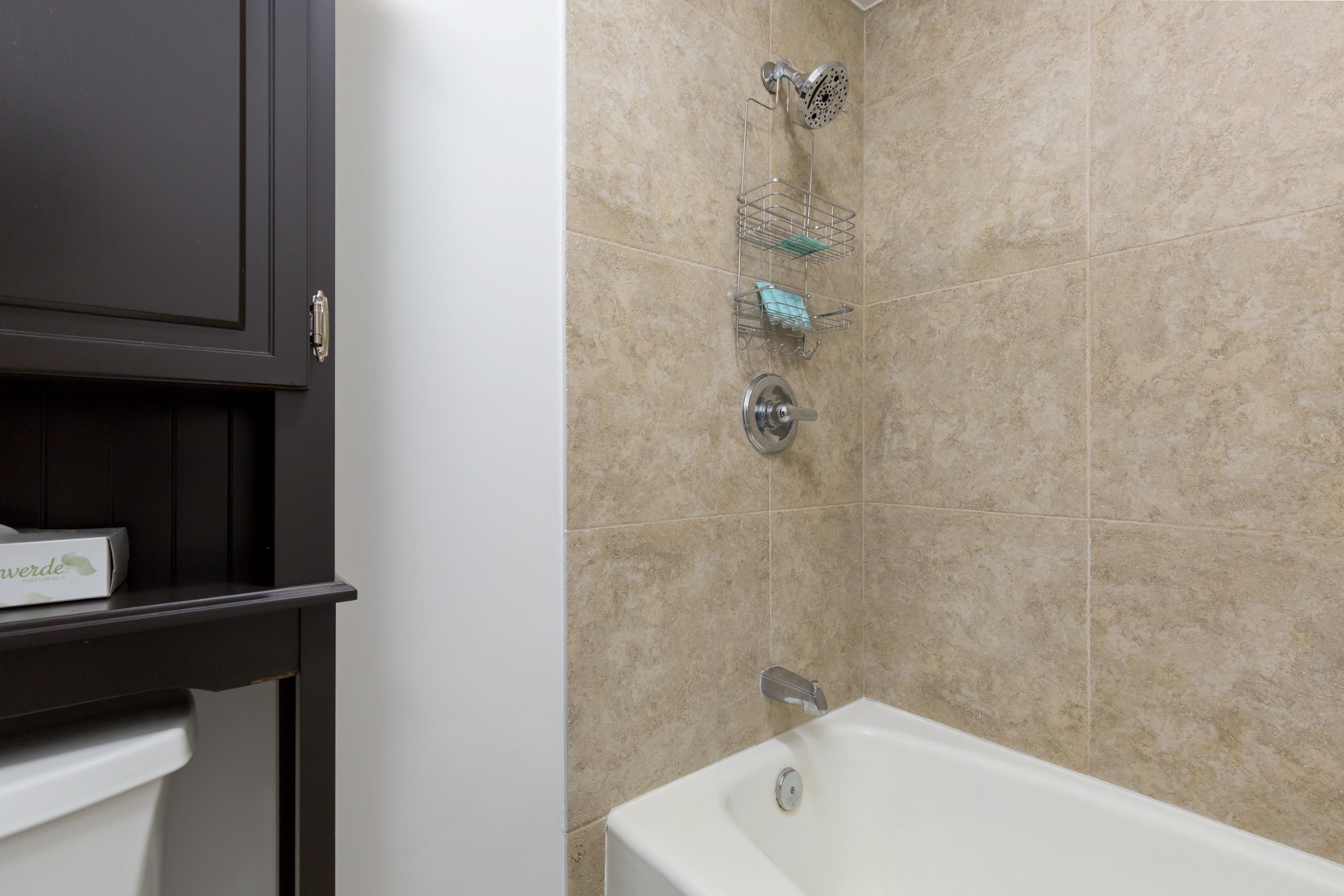 Slip into the clean, modern tub-shower combo with warm neutral tiles and thoughtful storage for your essentials—perfect for refreshing after a day exploring.