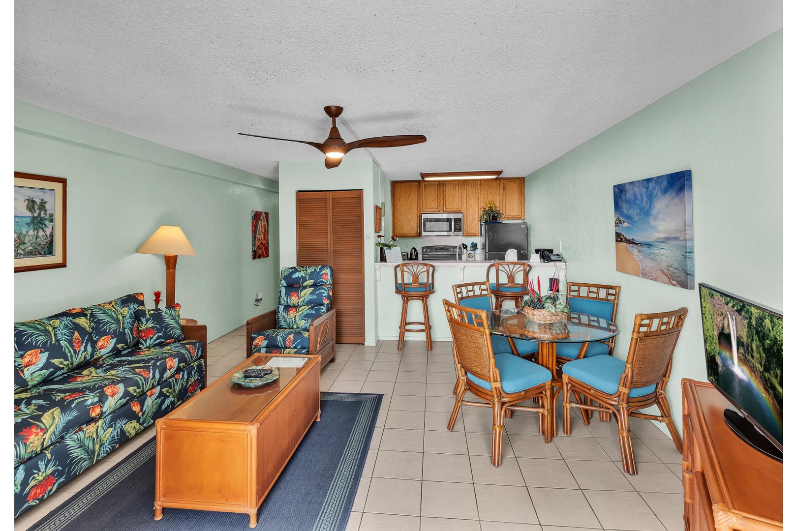 Relax in your tropical-themed living space with vibrant furnishings, open kitchen, and island-inspired décor creating the perfect vacation atmosphere.