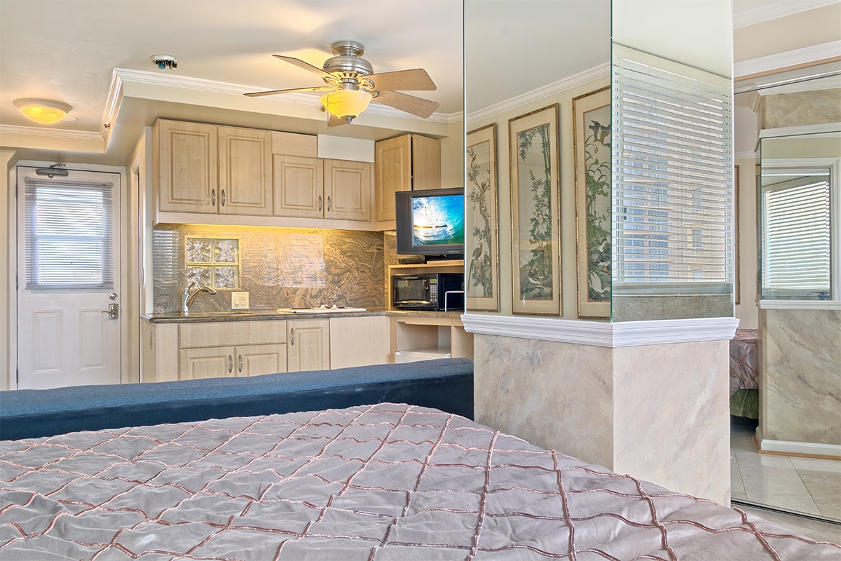 Your cozy studio blends restful sleeping space with a fully-equipped kitchen, perfect for preparing meals at home. Natural light pours through multiple windows, and modern conveniences like a microwave, ceiling fan, and TV ensure effortless comfort throug