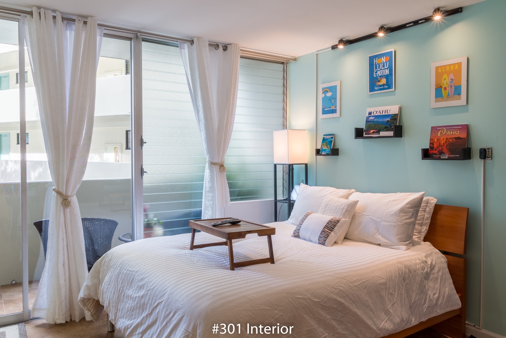 Sink into crisp white linens under soft lighting, surrounded by vibrant travel art and soothing colors. Your private balcony awaits just beyond the curtains.