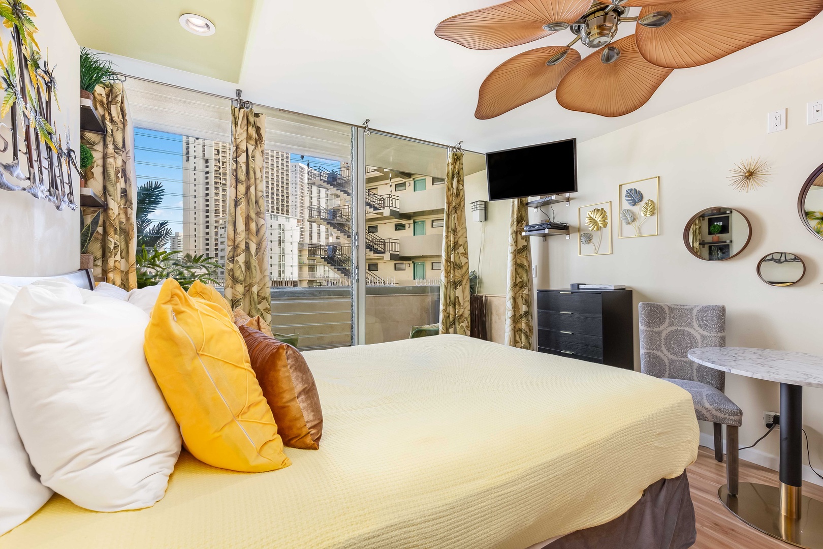 Sink into your cozy bed and wake to tropical palm fronds swaying just outside your window, with breezes from your ceiling fan and a peaceful view of the city beyond.