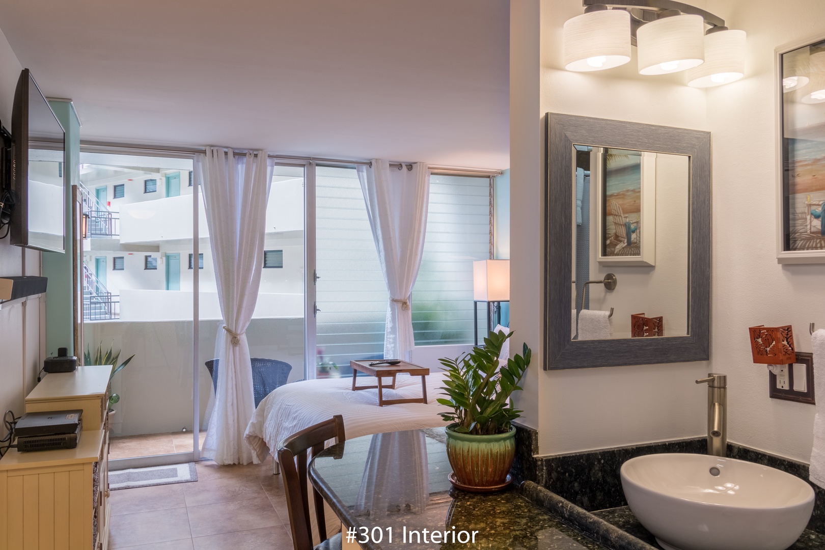 Step into your serene retreat where sunlight pours through elegant curtains and a private balcony awaits. Your modern bathroom features a sleek vessel sink, perfect for refreshing starts to your day.