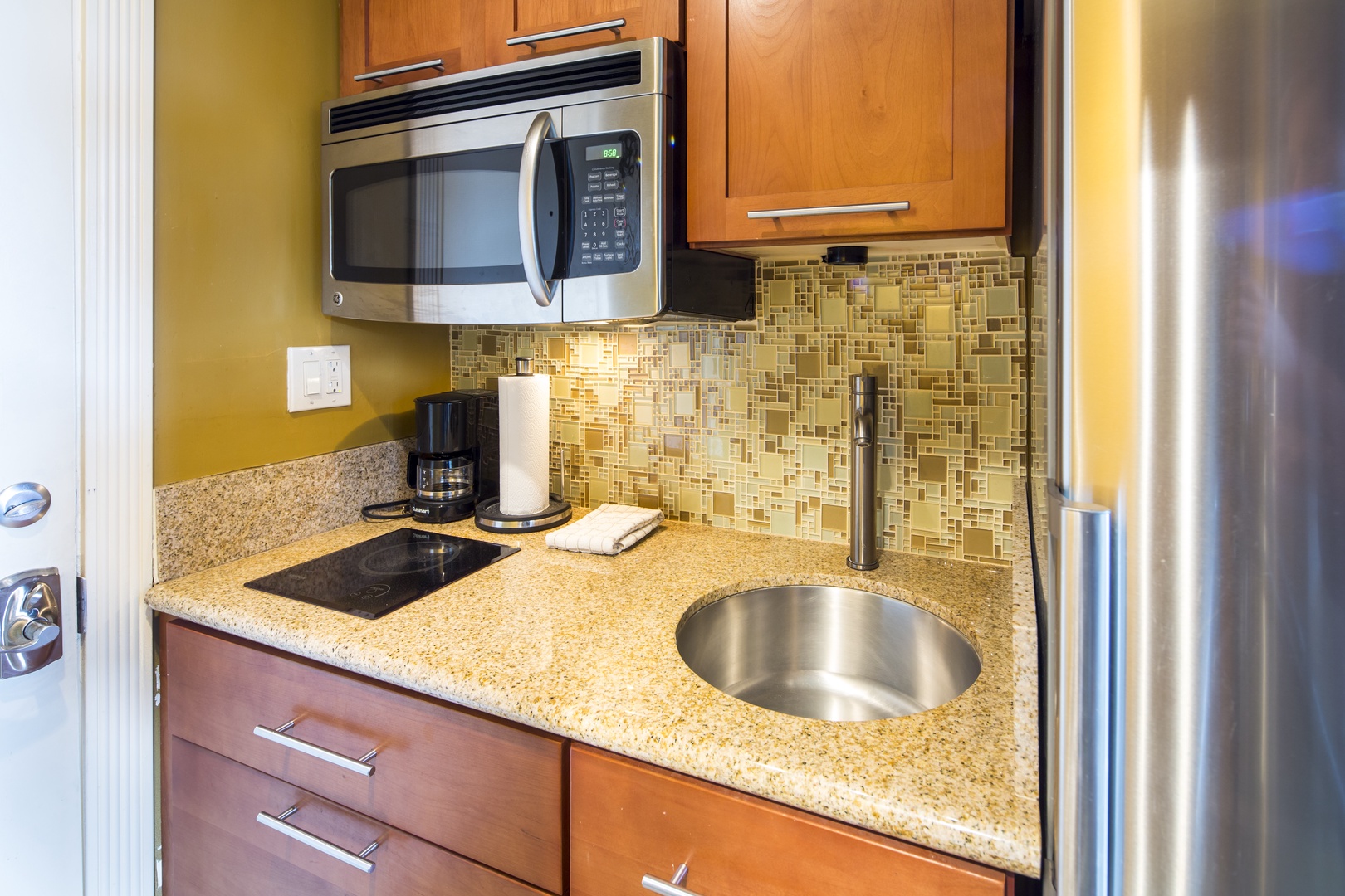 Your kitchenette has everything you need to whip up quick meals: stainless steel appliances, granite counters, a sleek backsplash, and a coffee maker ready for your morning brew.