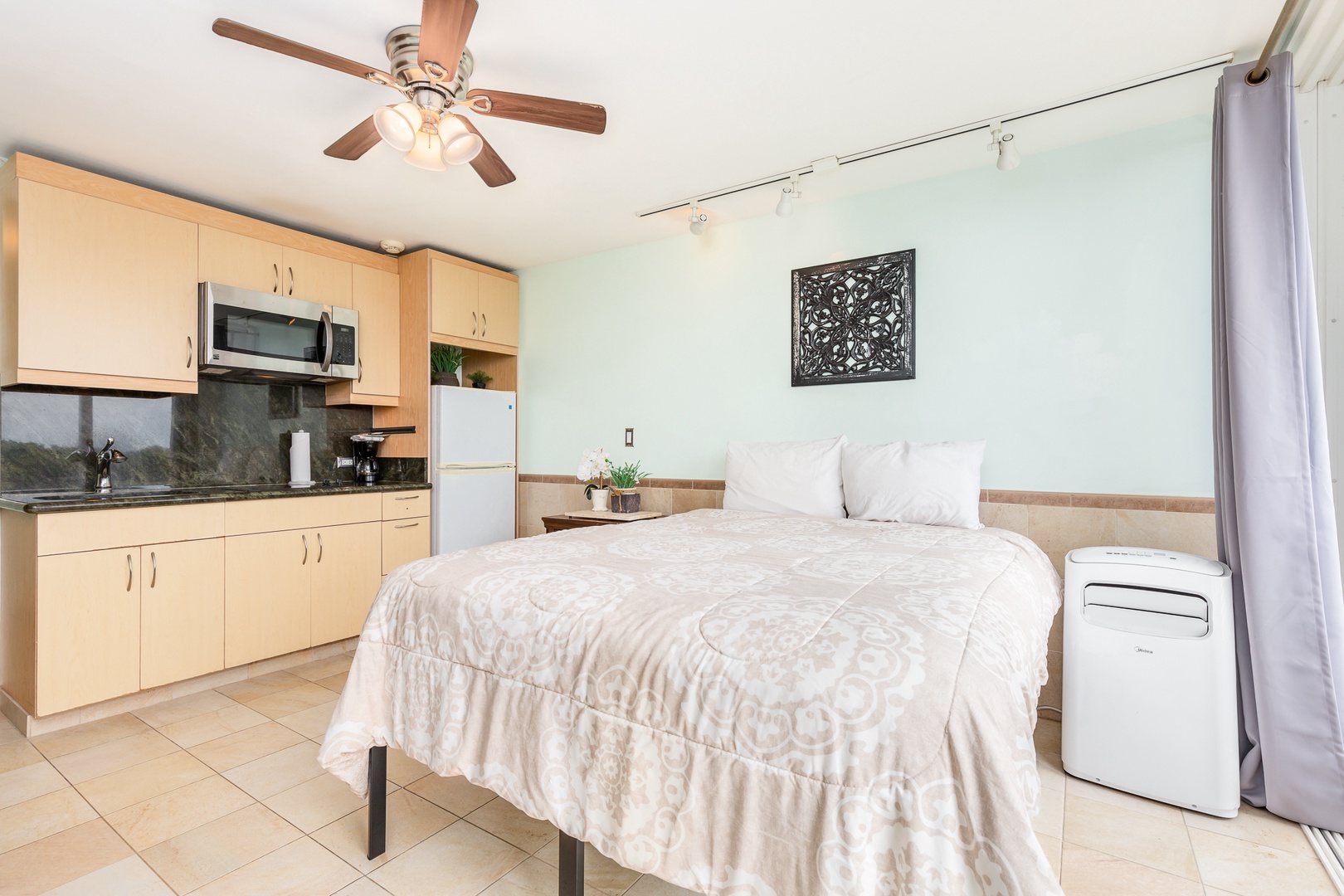 Your private studio combines comfort and convenience with a cozy bed, handy kitchenette, and modern amenities like a ceiling fan and portable AC—all in one thoughtfully designed space.