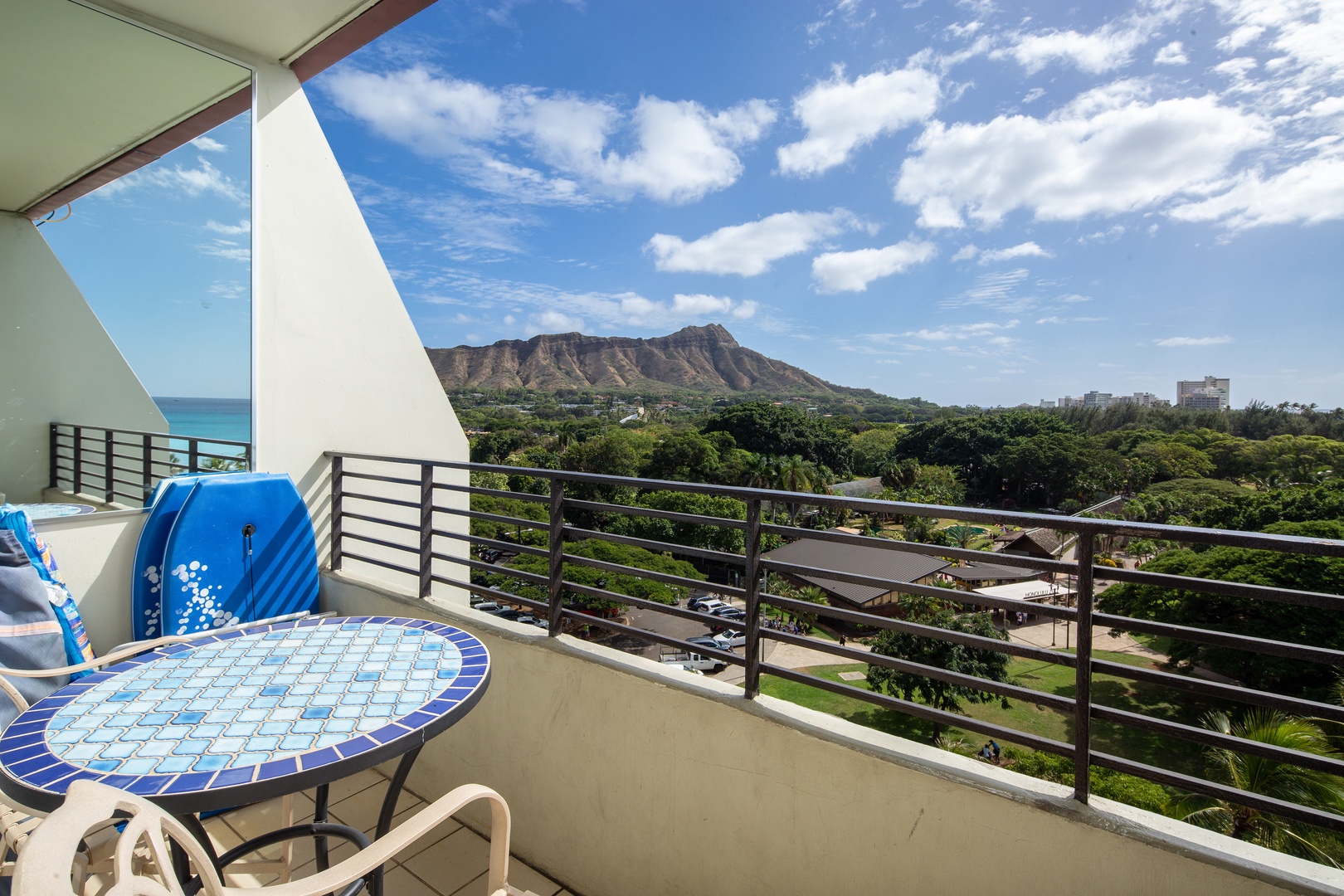 Iconic Diamond Head rises majestically beyond lush greenery, framing a stunning vista from this elevated balcony perch. Your morning coffee tastes even better with Hawaii's famous landmark and endless blue sky in full view.