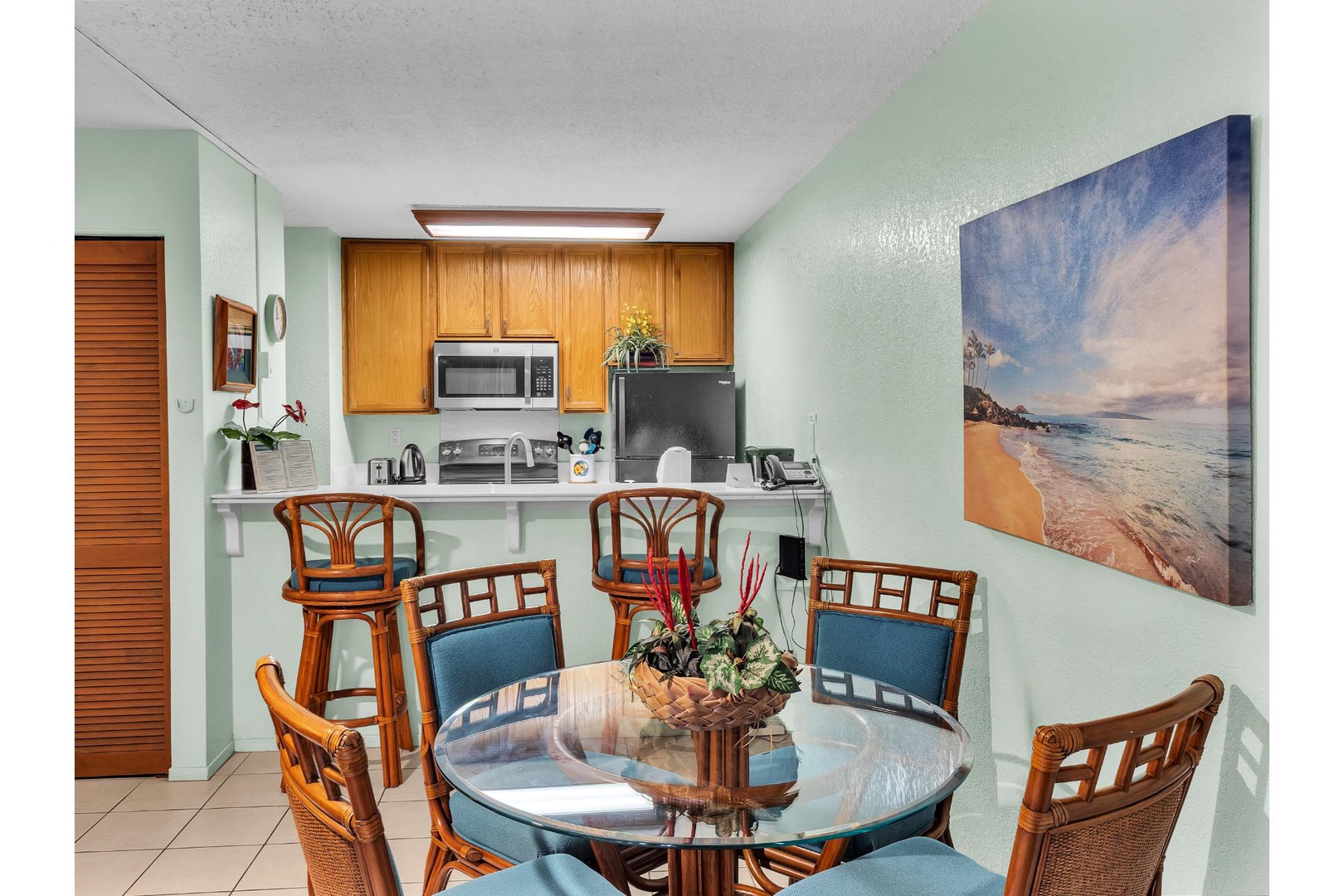 Your tropical dining space features warm bamboo furniture and a fully equipped kitchen, perfect for sharing meals after beach adventures.