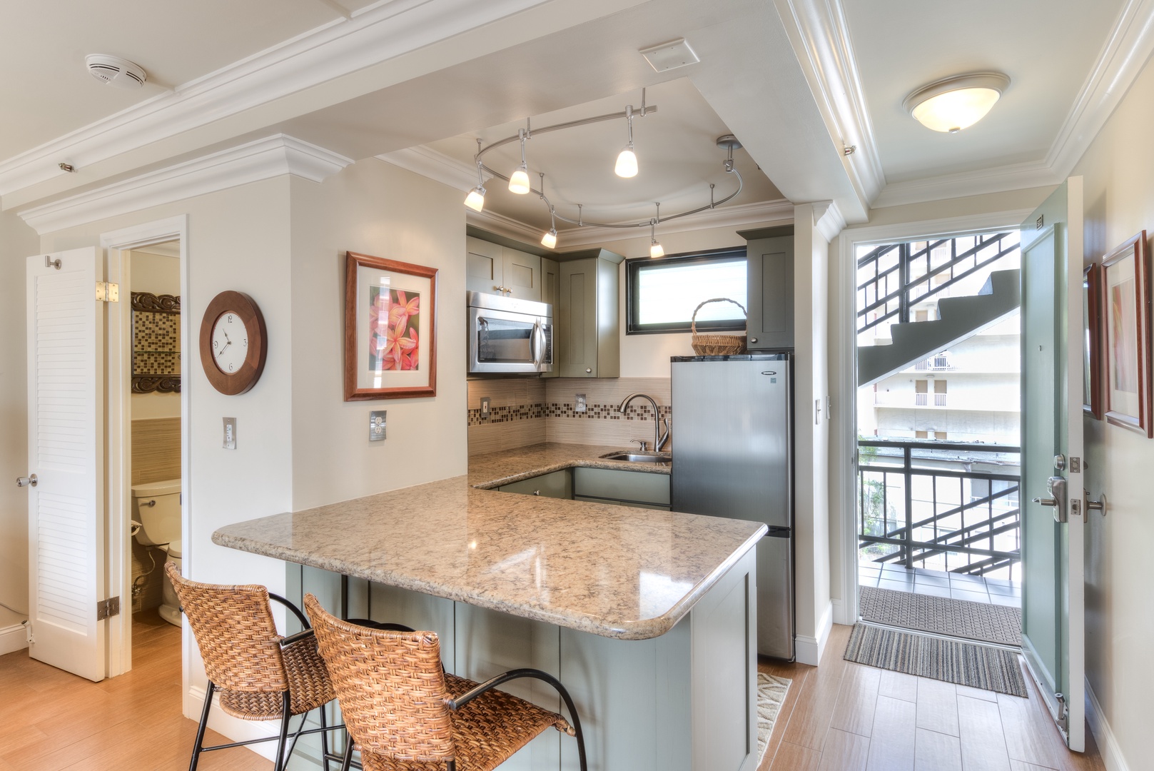 Your well-equipped kitchen features granite counters, stainless appliances, a breakfast bar with seating, and stylish track lighting—perfect for easy meal prep during your stay.