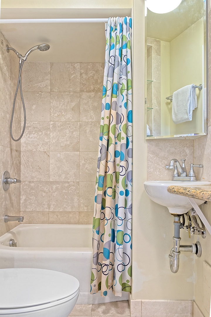 Refresh in your private tiled bathroom with a cheerful shower-tub combo, sink, and all the essentials for a comfortable stay.