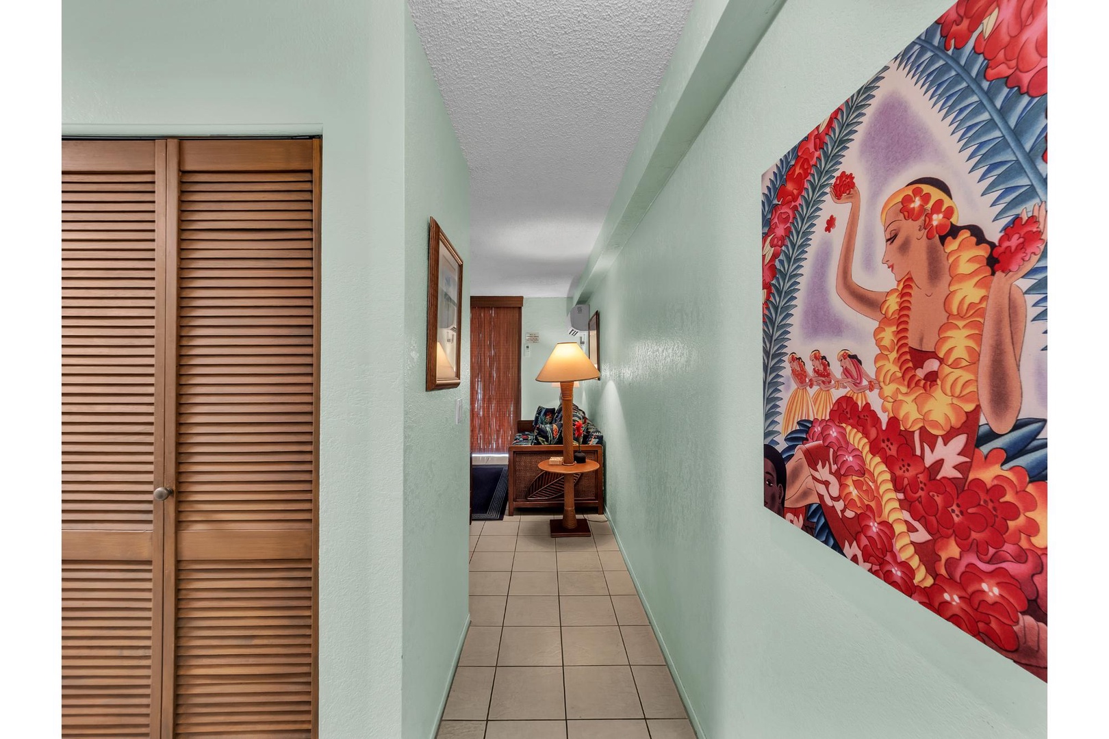 Step into your tropical haven where vibrant Hawaiian artwork welcomes you through this charming hallway to your peaceful retreat.