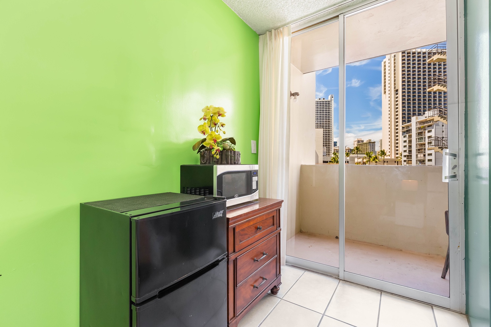 Your cozy kitchenette offers a mini-fridge, microwave, and private balcony where you can savor morning coffee with vibrant city views framed by towering high-rises.