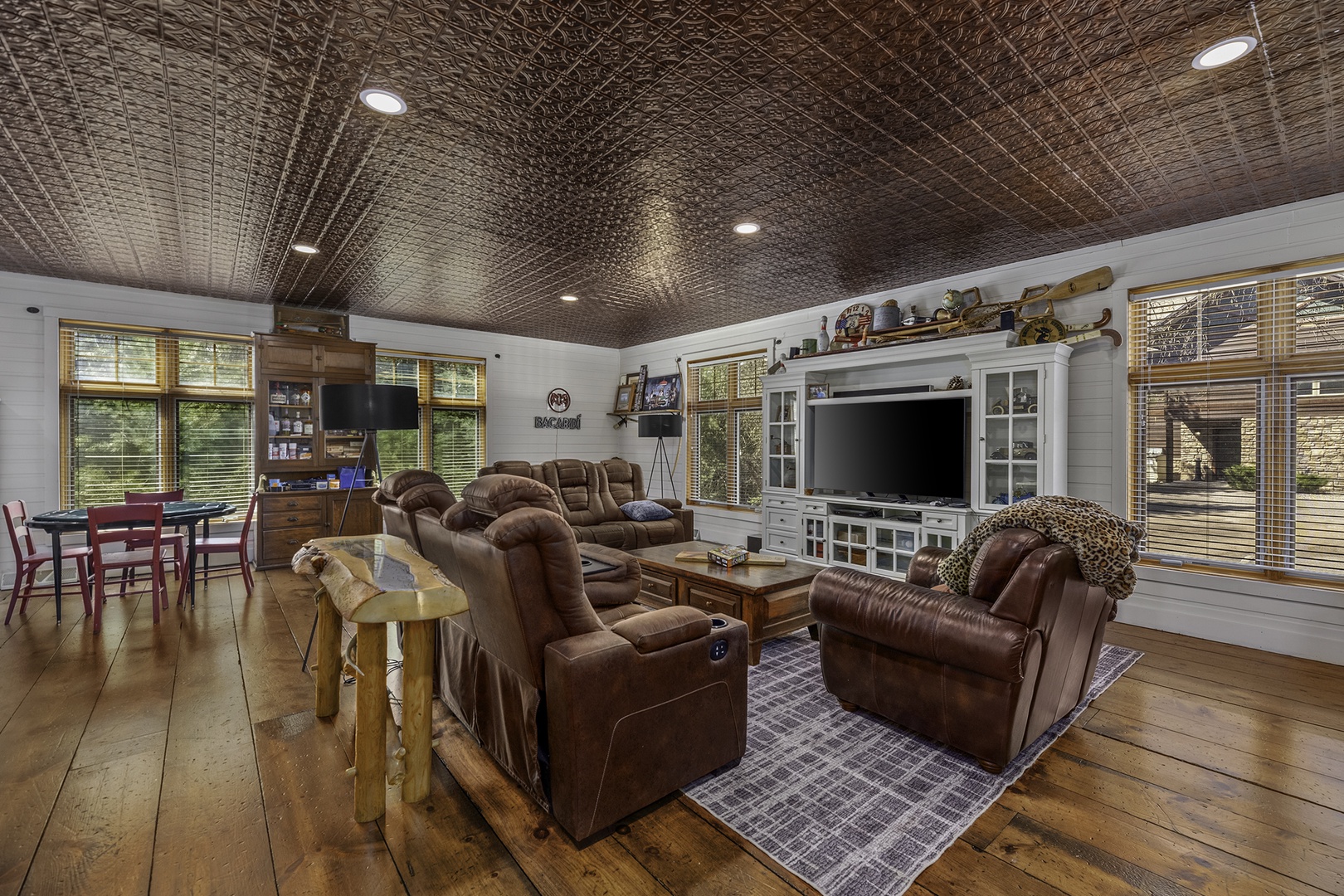 Sink into plush leather recliners and unwind in this inviting living room, where a stunning tin ceiling and warm wood floors create a cozy retreat for movie nights and quality time together.