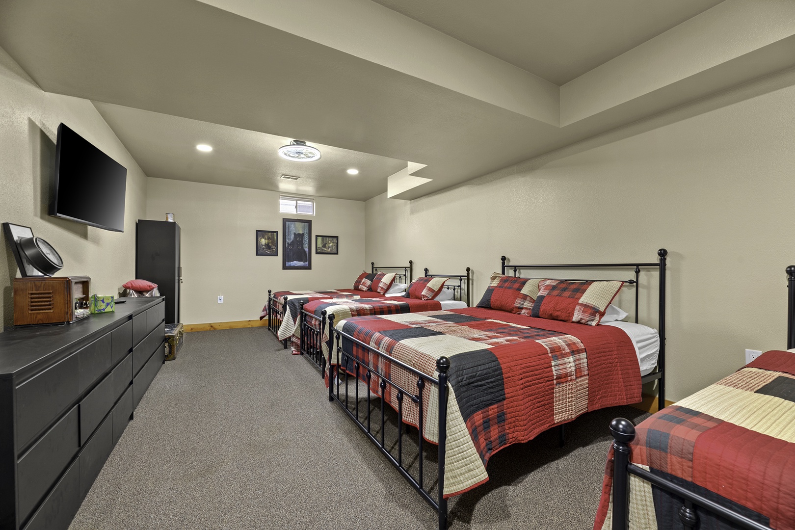 Gather your group in this spacious multi-bed room featuring classic metal frames and cozy quilted bedding. Enjoy entertainment on the wall-mounted TV and ample storage in the sleek dresser.
