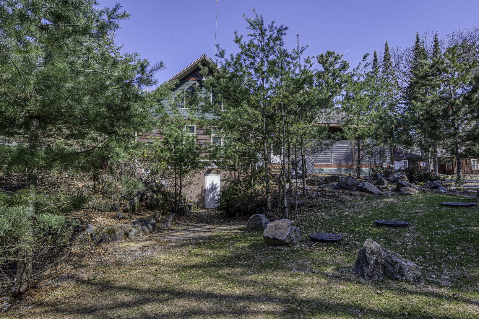 Rustic cabin nestled among towering pines and natural rock formations, offering a peaceful retreat surrounded by forest and resort charm.