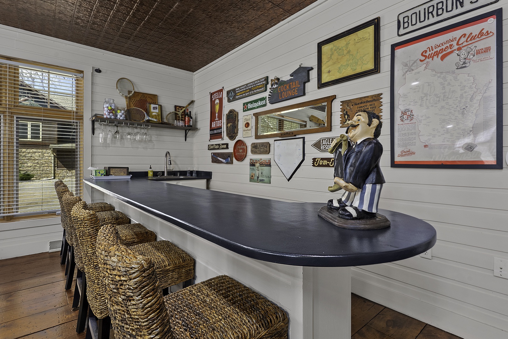 Your private bar awaits! Pull up a woven stool and mix your favorite drinks beneath vintage signs and a rustic tin ceiling—perfect for unwinding