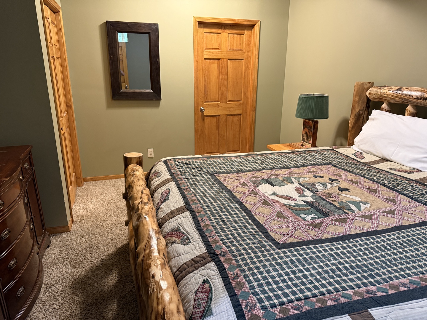 Cozy rustic bedroom with handcrafted log furniture and warm quilted bedding invites you to unwind after a day of adventure.
