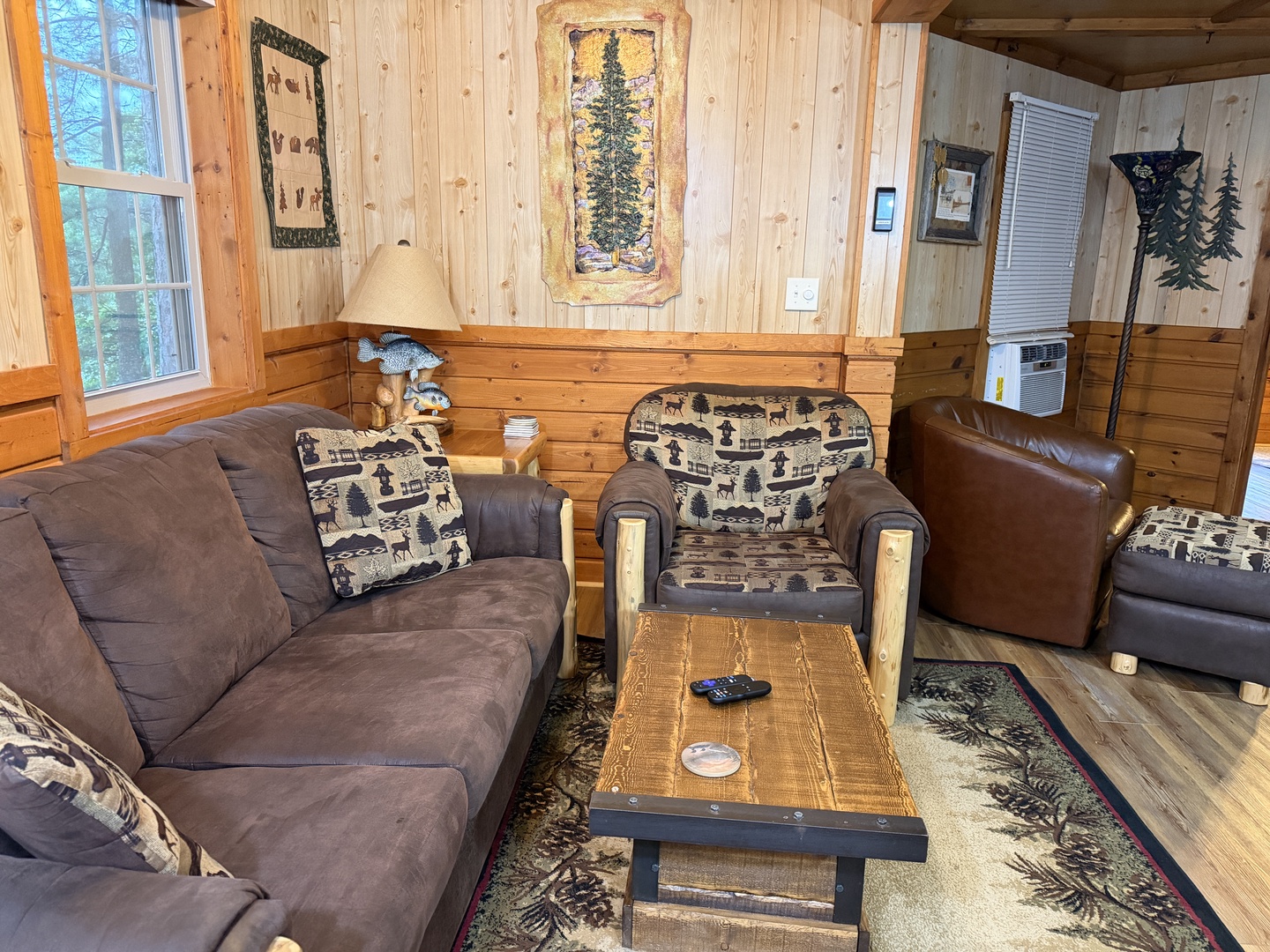 Sink into plush seating surrounded by warm wood paneling and rustic decor. Your woodland retreat features charming wildlife accents and natural light from forest views outside your windows.