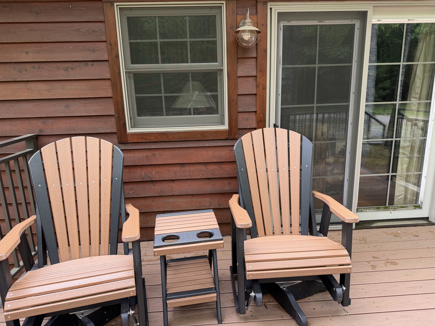Your private deck welcomes you with Adirondack gliders and a small side table—perfect for morning coffee or evening relaxation under the lantern glow.