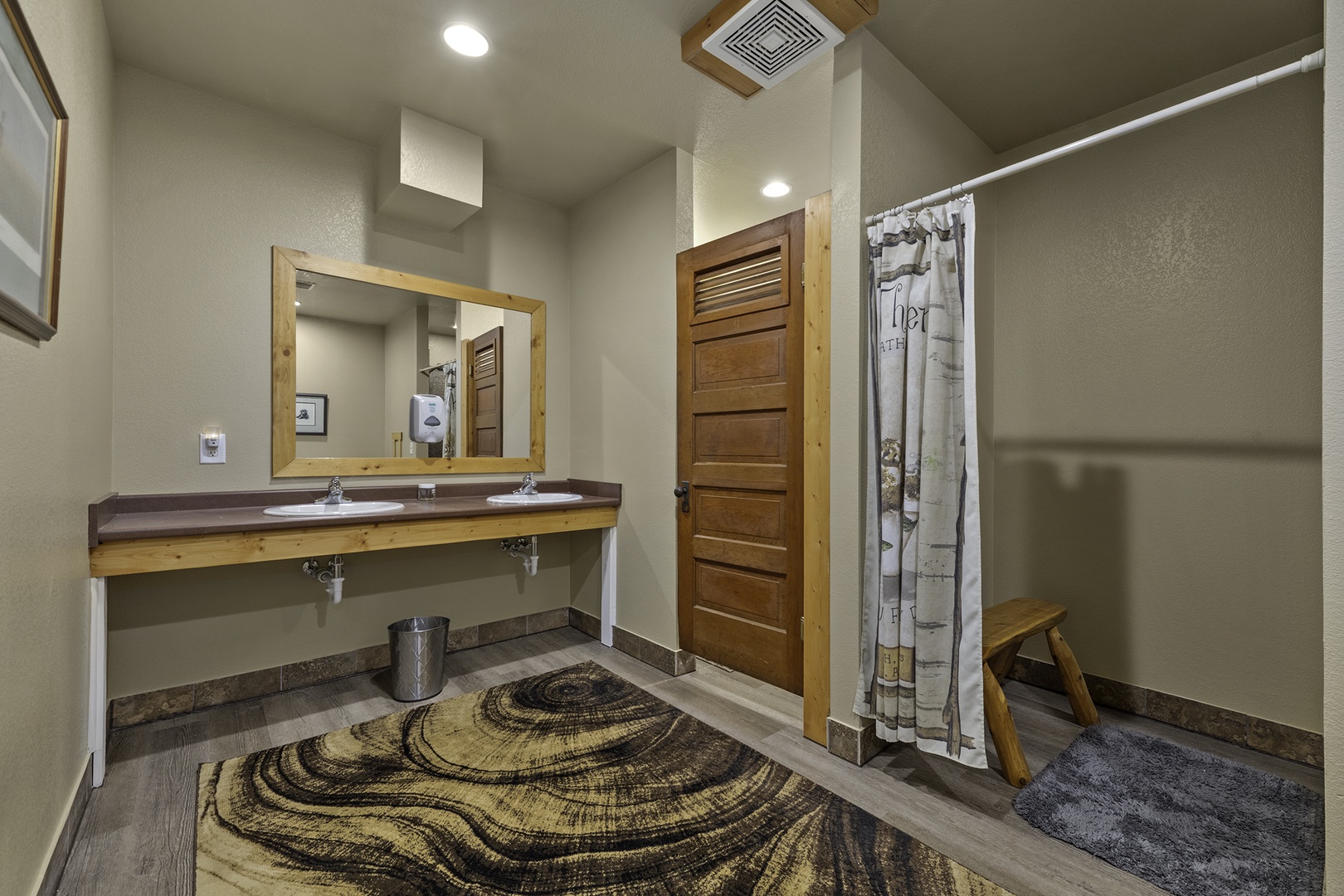 Step into your spacious bathroom where rustic wood accents meet modern comfort. Double sinks under a natural wood-framed mirror give you plenty of room to get ready for your  adventure.