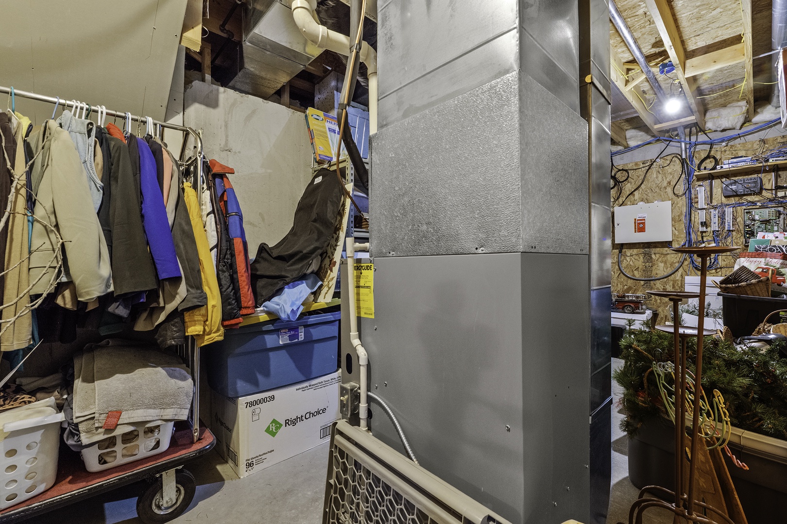 Storage and utility area with hanging wardrobe, cleaning supplies, and organized shelving—practical behind-the-scenes space supporting your stay.