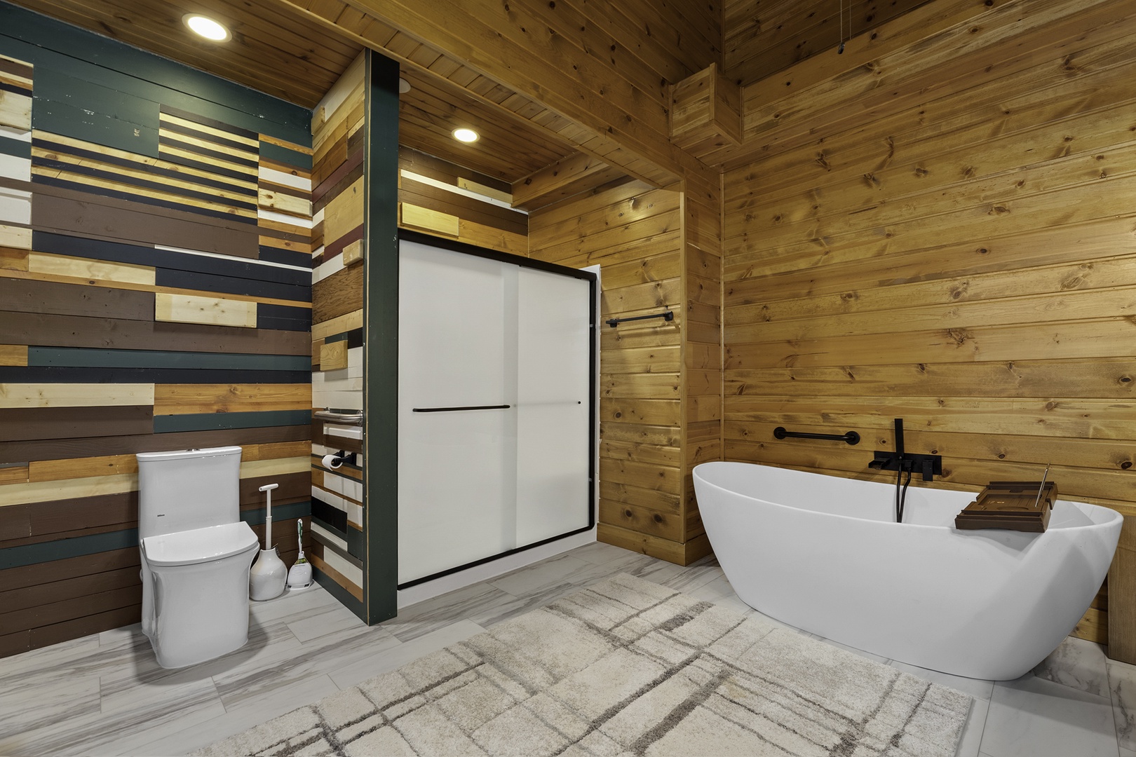Soak away your cares in this stunning freestanding tub, surrounded by warm wood and modern style. The spacious walk-in shower and private toilet area make this your perfect retreat.