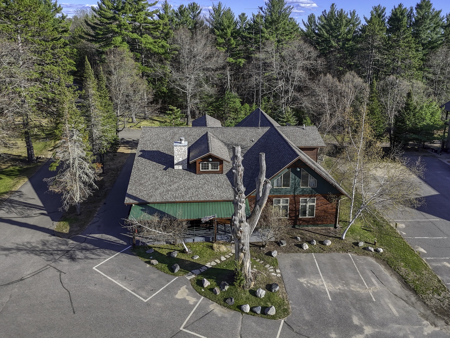 A charming  lodge nestled among towering pines and birch trees, offering tranquil forest surroundings with convenient parking and easy access to nature.
