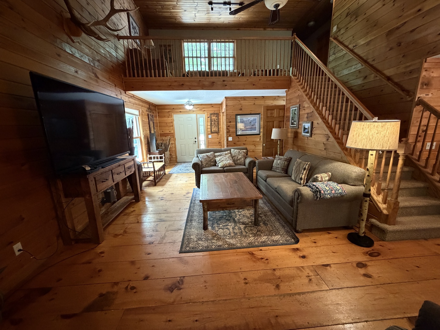 Relax in your inviting living room with vaulted wood ceilings, cozy furnishings, and a modern TV. The loft overlooks the space, adding rustic charm and room to unwind after a day of adventure.