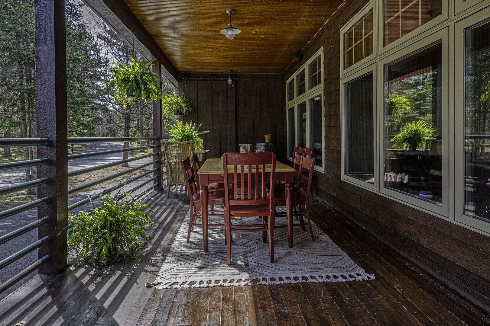 Picture yourself savoring morning coffee or enjoying dinner at your private covered porch, surrounded by lush ferns and peaceful forest views. The warm wood tones and natural light create an inviting space for memorable meals.