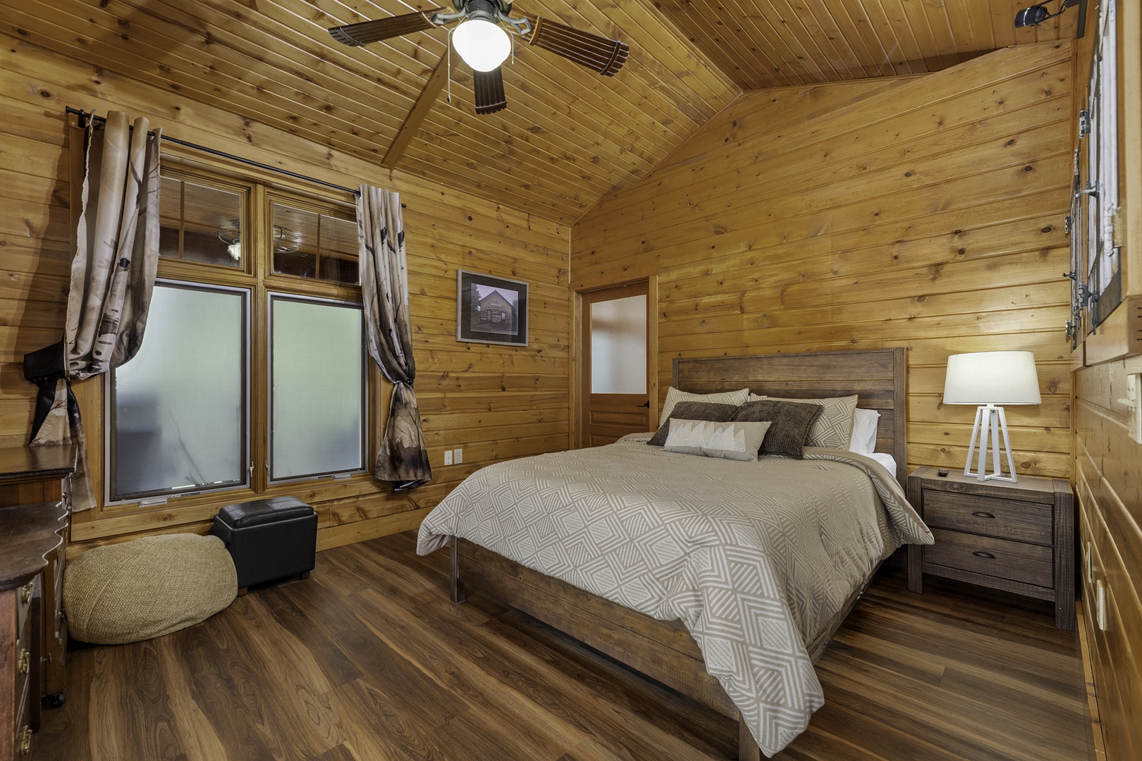Unwind in your warm, wood-lined retreat with vaulted ceilings, plush bedding, and soft lighting—your perfect  escape awaits.