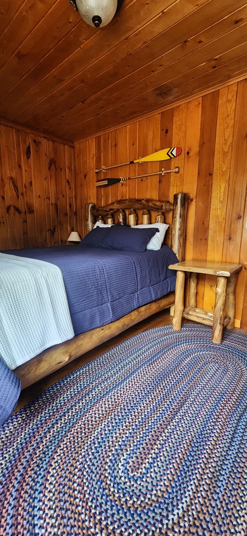 Curl up in your rustic bedroom, where handcrafted log furniture and knotty pine walls create a cozy retreat for restful nights.