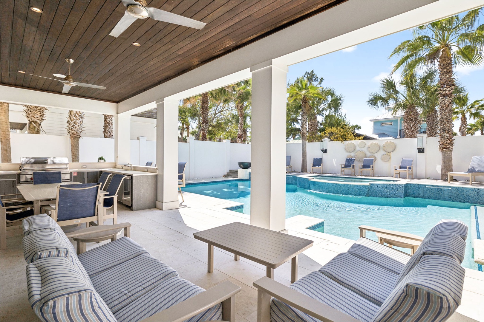 Relax in your private poolside oasis with comfortable outdoor seating, tropical palms, and crystal-clear waters steps from your covered terrace.