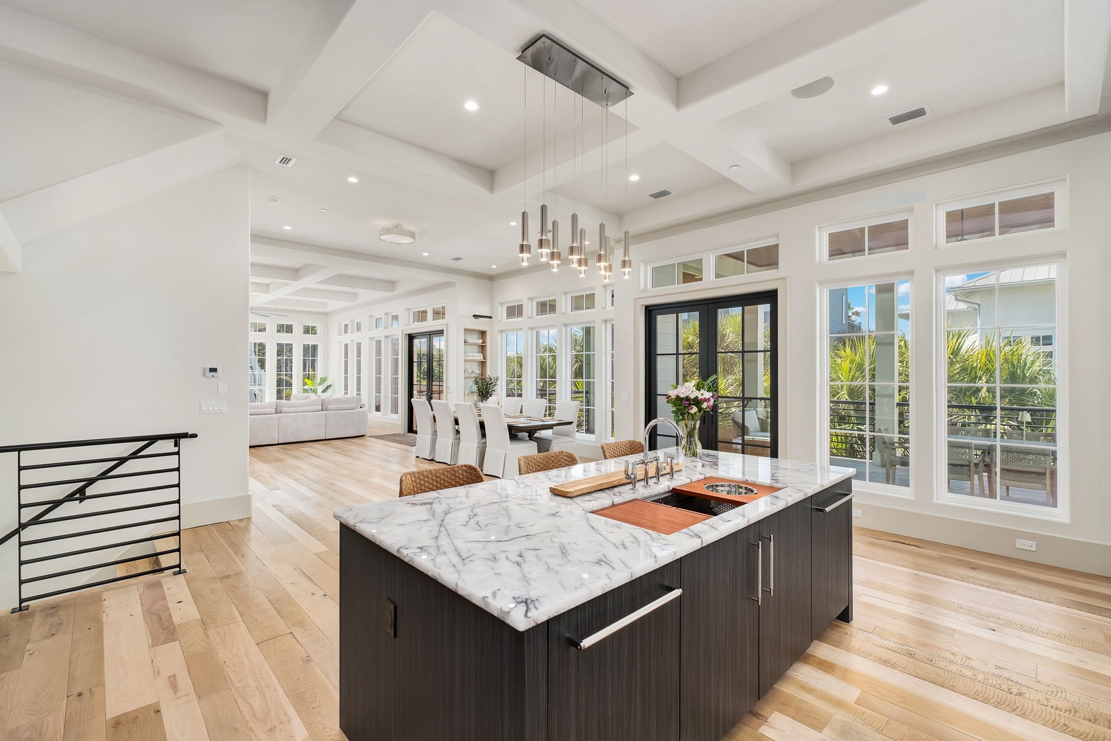 Your dream kitchen awaits with marble countertops, modern fixtures, and warm wood floors flowing into bright dining spaces.