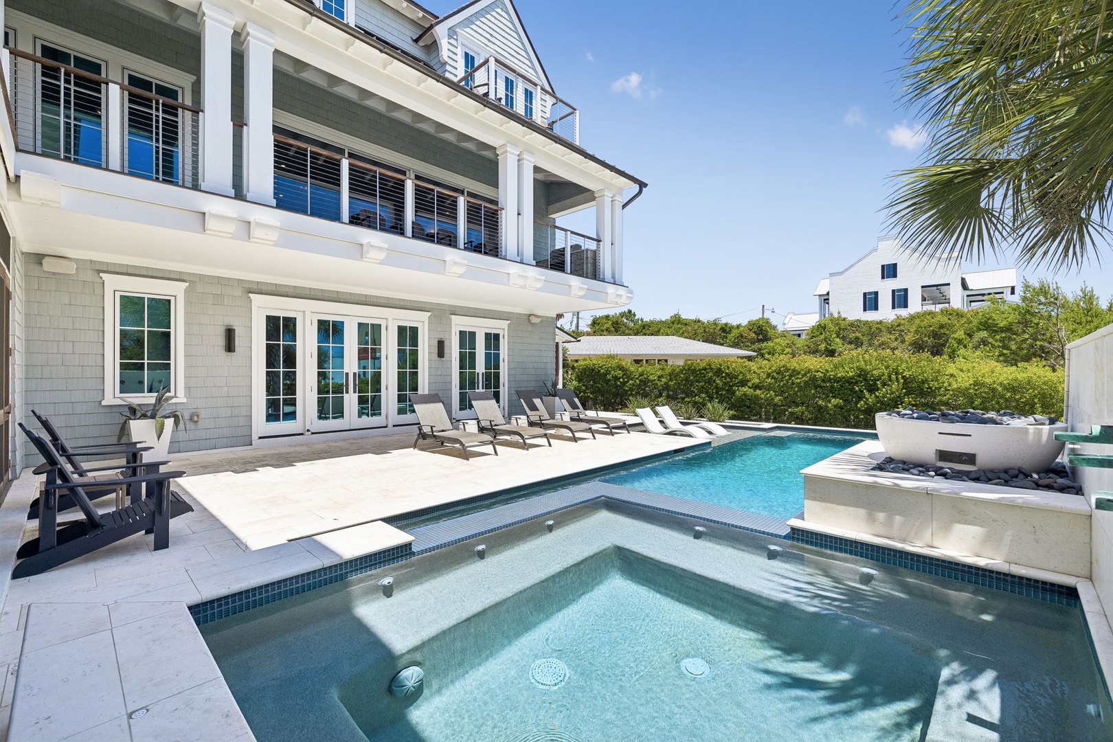 Coastal elegance with a stunning pool, spacious lounging areas, and tropical palm breezes—your private oasis awaits under bright skies.