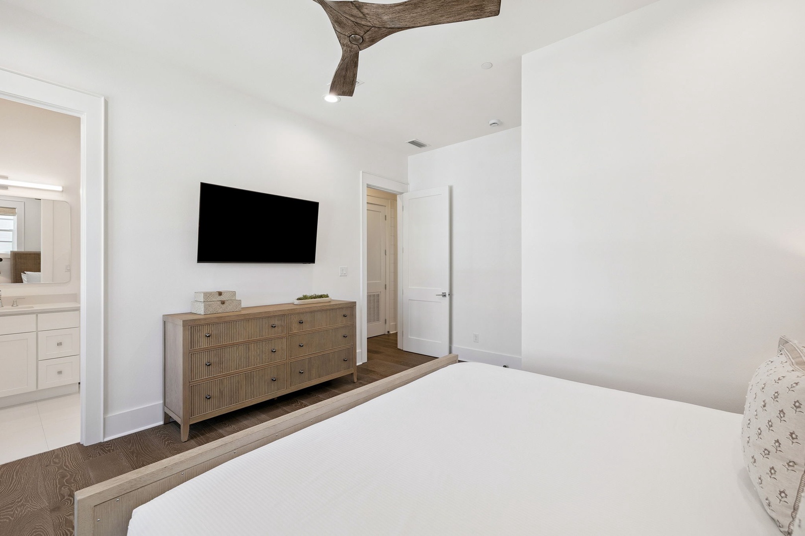 Unwind in your serene bedroom featuring rustic wooden beams, modern amenities, and crisp white linens for ultimate comfort.