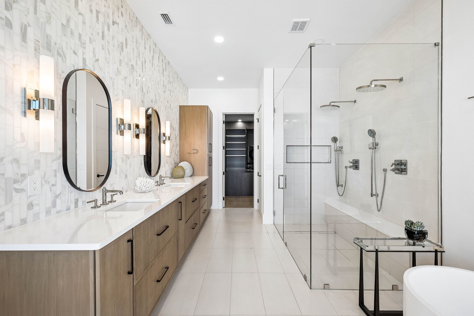 Step into your pristine spa-like ensuite, where dual vanities, gleaming glass shower, and elegant modern finishes welcome you to unwind in style.